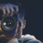 a man photographer with a camera takes a photo in the dark, copy space.